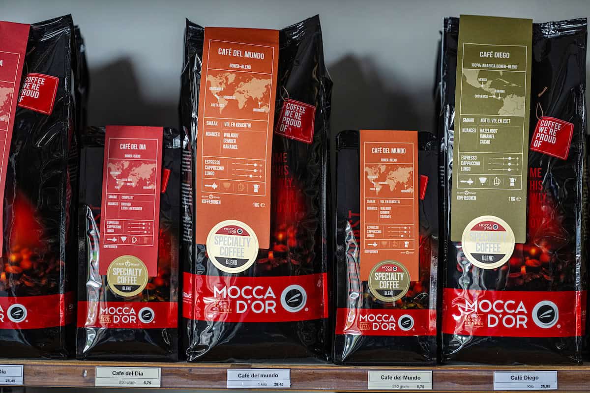 Gezellige koffie-en theelokale winkel met Premium koffiebonen verpakt in kleurrijke zakken voor een rijke smaak en aroma.