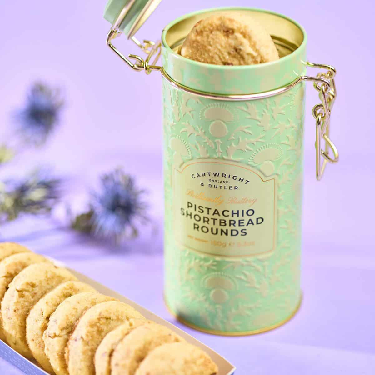 Zachte pistachio shortbread koekjes in een elegante, mintgroene blik met gouden details, perfect voor bij koffie of thee. Authentieke smaak en mooie presentatie voor elke gelegenheid.